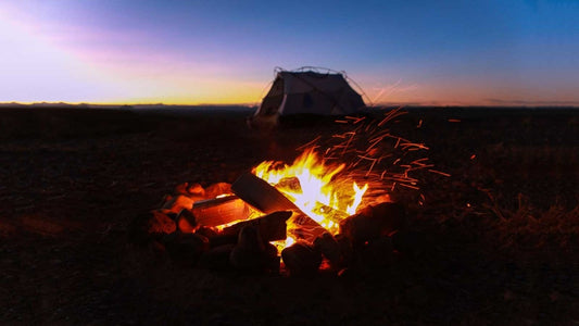 a well built campfire with a tent nearby