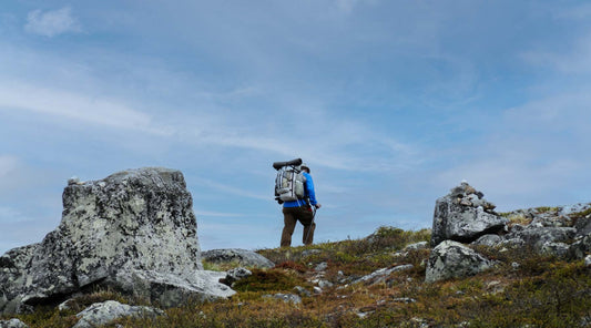 Backpacker hiking along a mountain ridge trail.