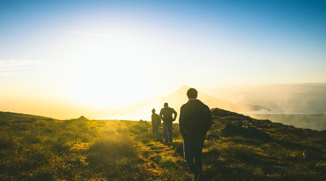 Group of friends hiking towards the sunrise on a clear morning.