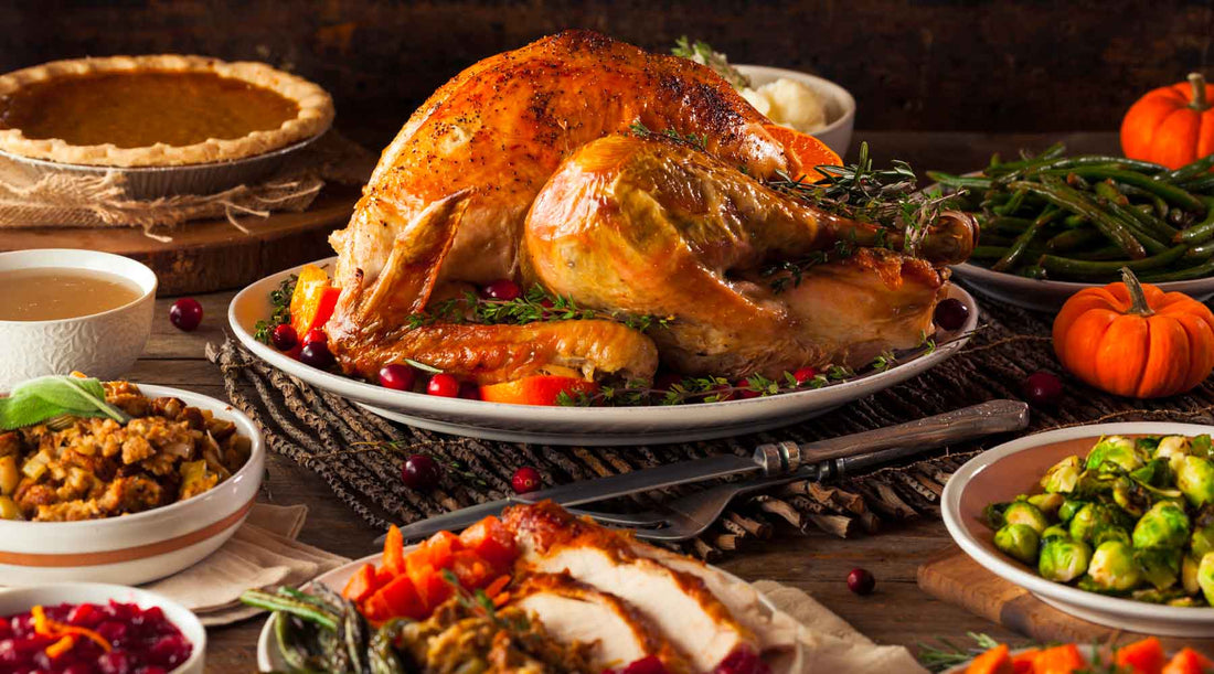 Cabin table set with Thanksgiving meal with big turkey, pumpkin pie, stuffing, mashed potatoes, and other sides. 