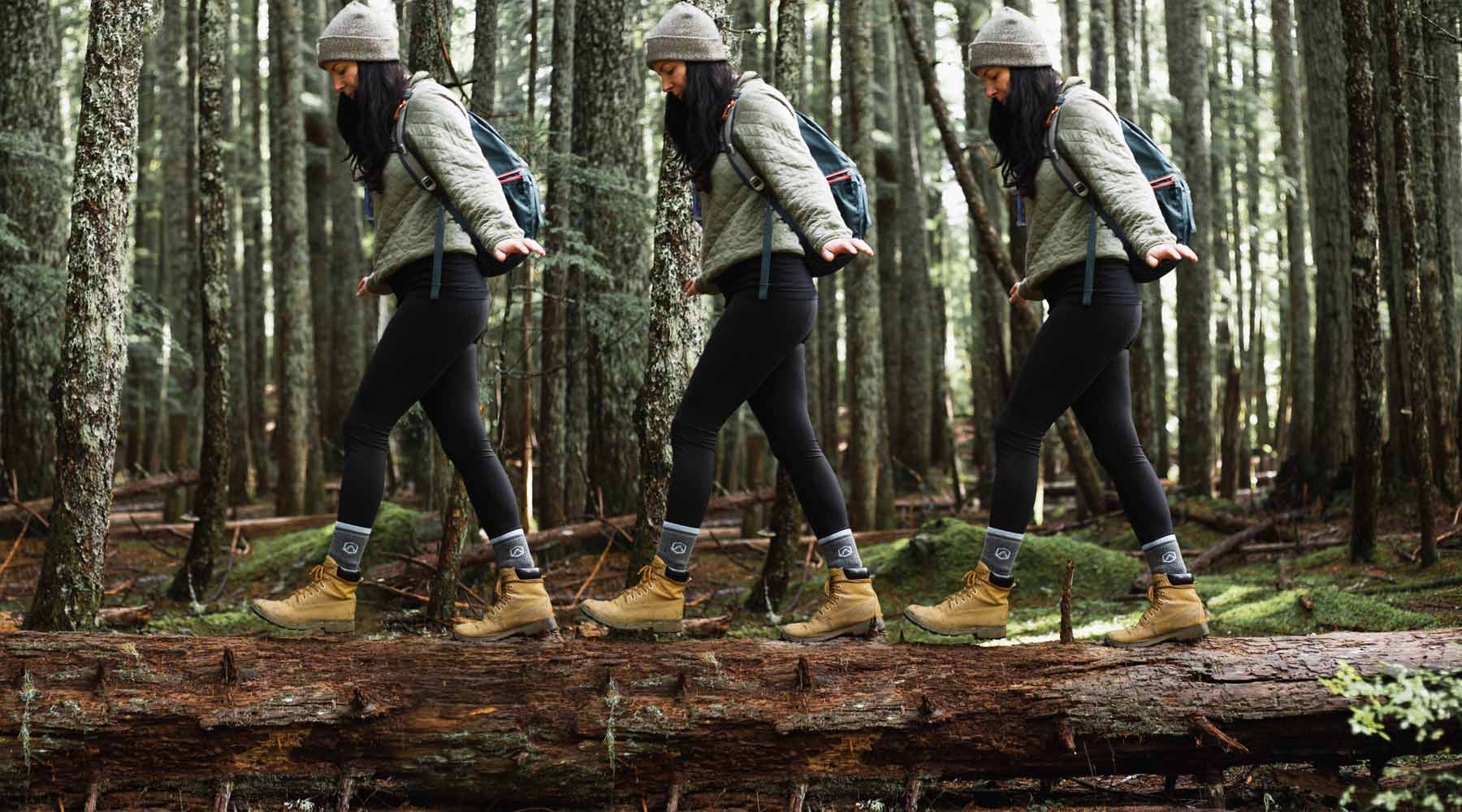 Women wearing Cloudline socks walking across log. 