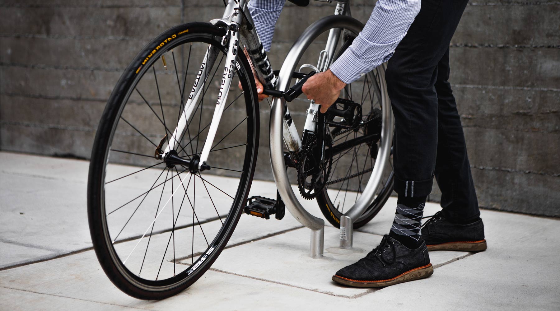 Bike commuter wearing Cloudline dress socks while locking up bicycle.