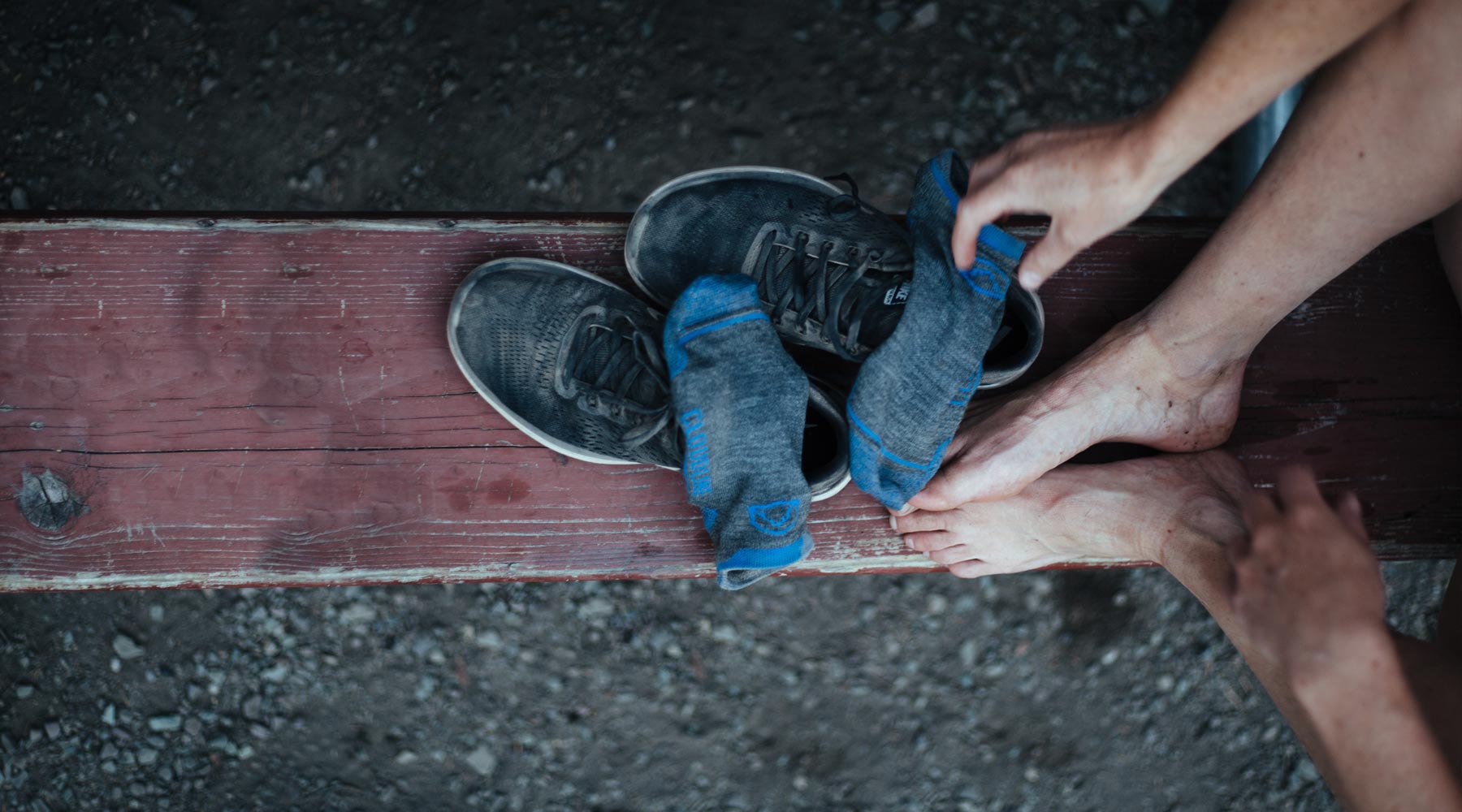 Runner sitting on bench after a run with Cloudline socks and running shoes off. 