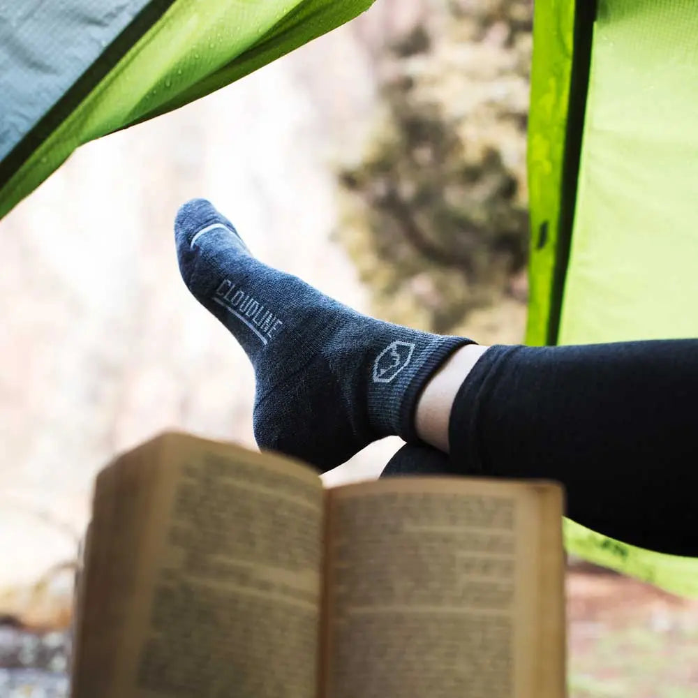 Women reading in tent wearing Cloudline Quarter Top Merino Wool Running Sock - Light Cushion - Granite