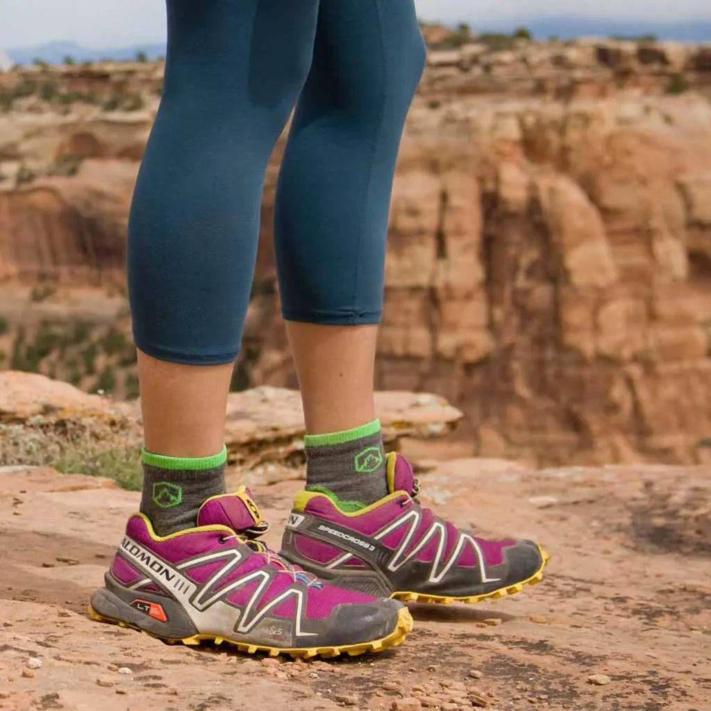 Hiker standing on canyon rim wearing Cloudline 1/4 top merino wool socks.