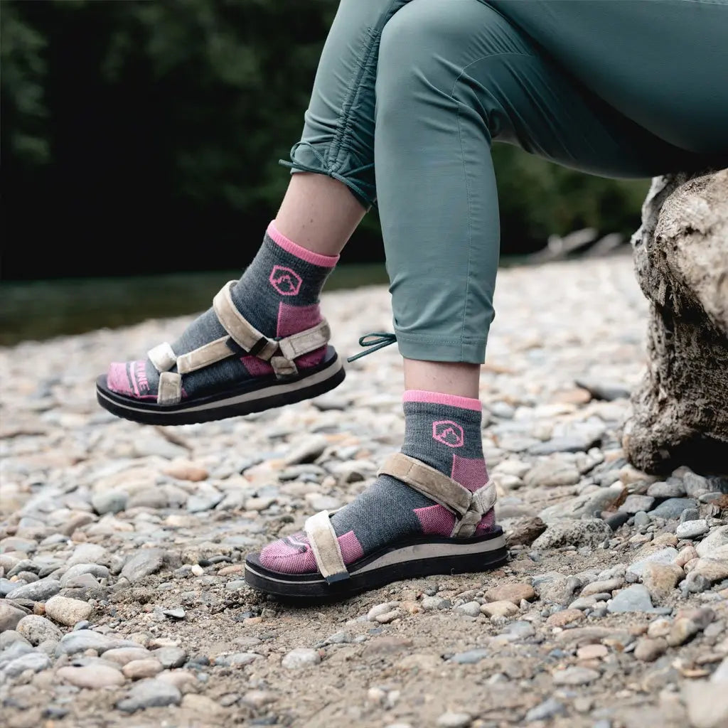 Hiker sitting next to river wearing Cloudline 1/4 top merino wool socks.