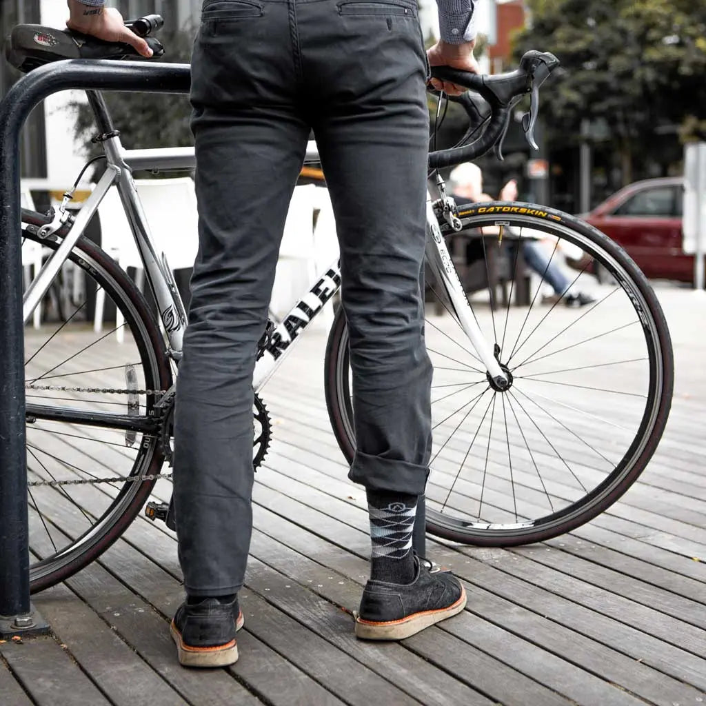 Biker in dress clothes locking bike to rack while wearing Cloudline merino wool dress socks.