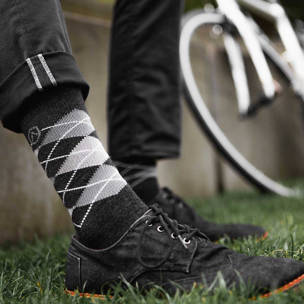 Man sitting next to bicycle wearing Cloudline active dress socks. 