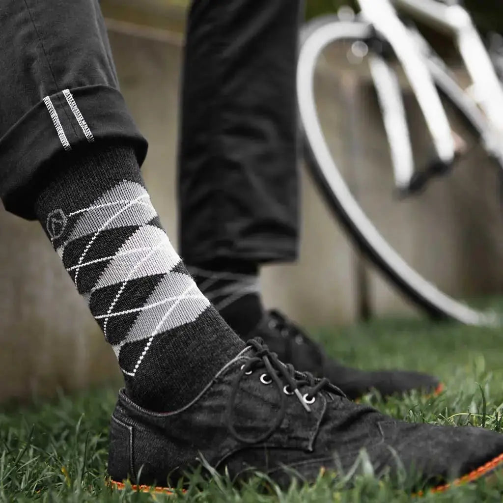 Man sitting next to bicycle wearing Cloudline merino wool active dress socks.