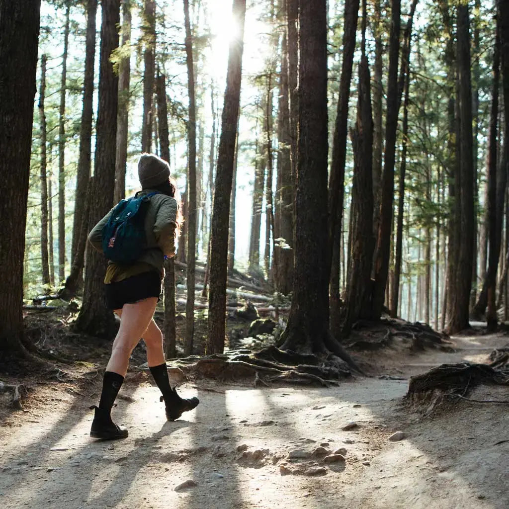 Women wearing Cloudline merino wool compression socks hiking through forest