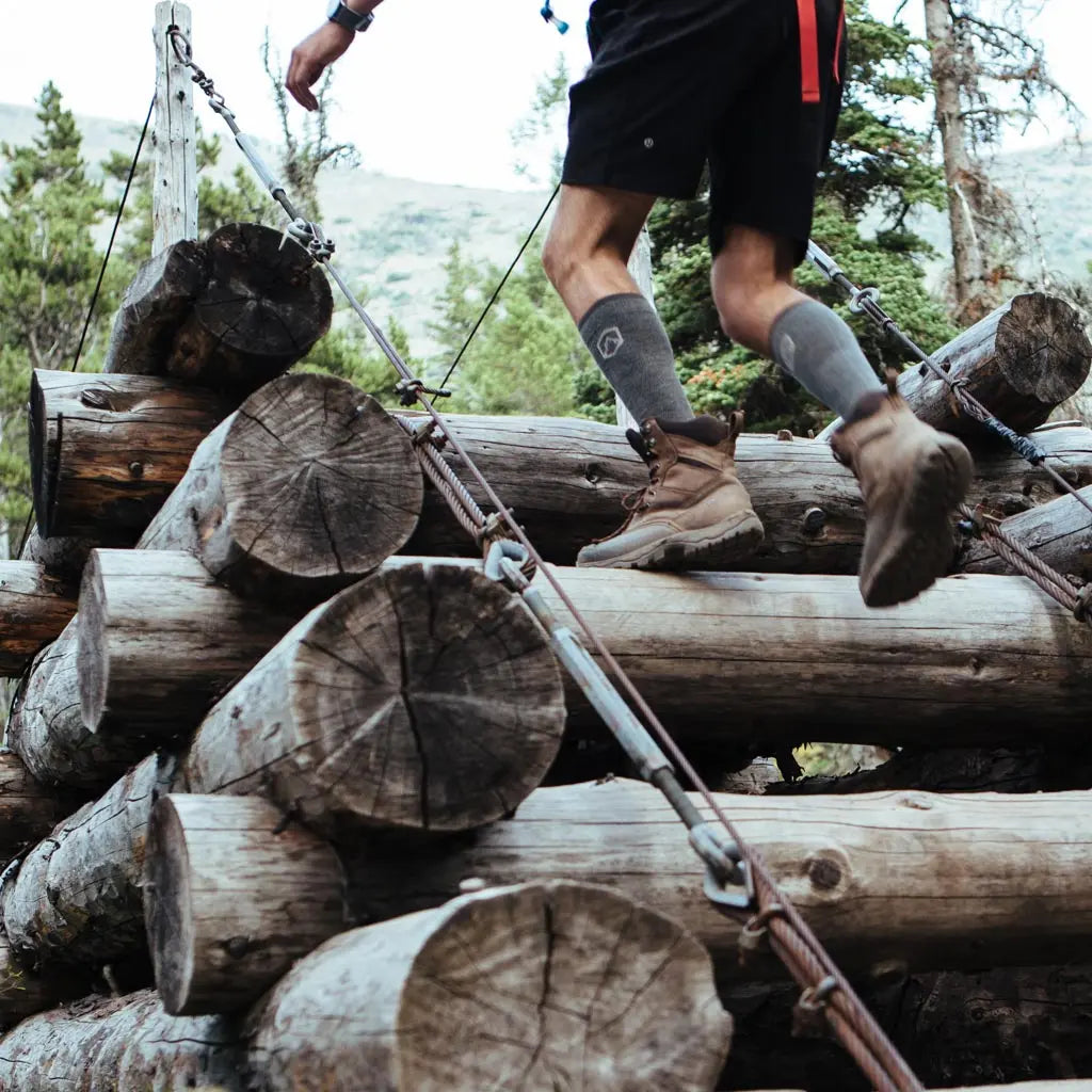 Hiker climbing wooden stairs wearing Cloudline merino wool compression socks.