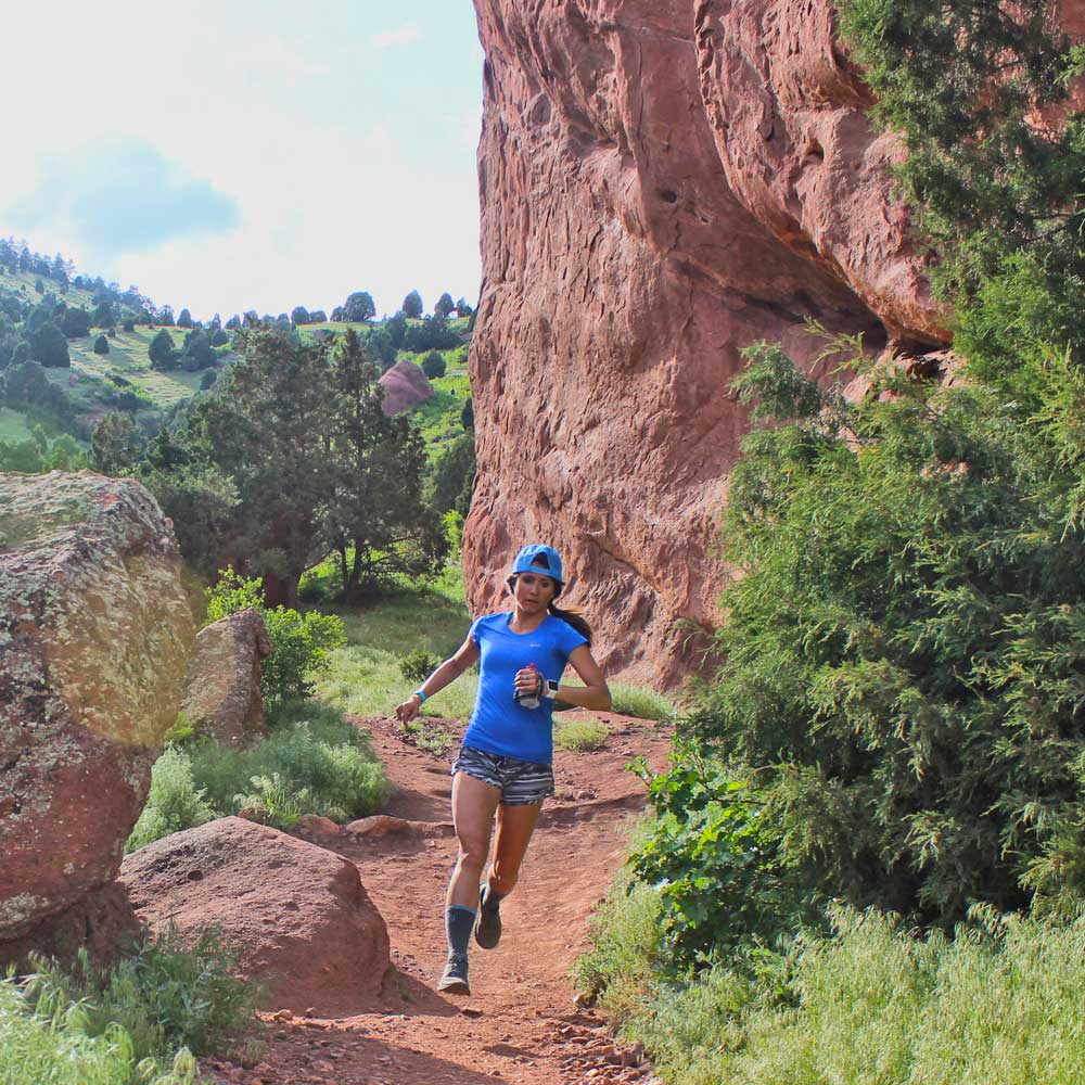 Women wearing Cloudline merino wool hiking socks while trail running on sunny day.