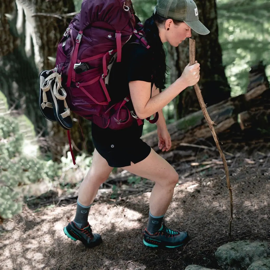 Women backpacking on trail wearing Cloudline merino wool hiking socks.