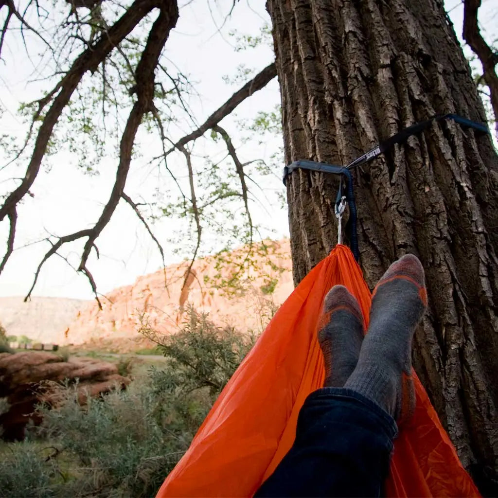 Camper laying in nylon hammock with shoes of wearing Cloudline merino wool hiking socks.