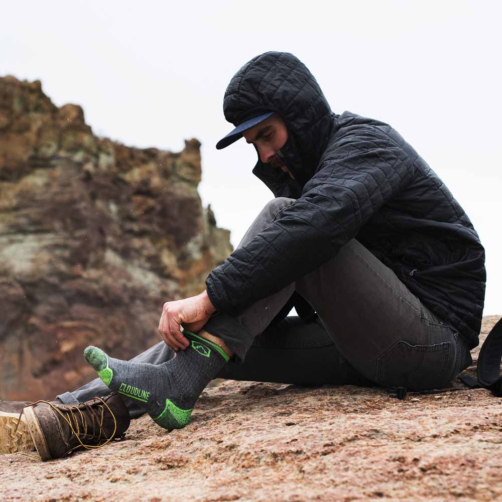 Hiker pulling on a pair of Cloudline merino wool hiking socks