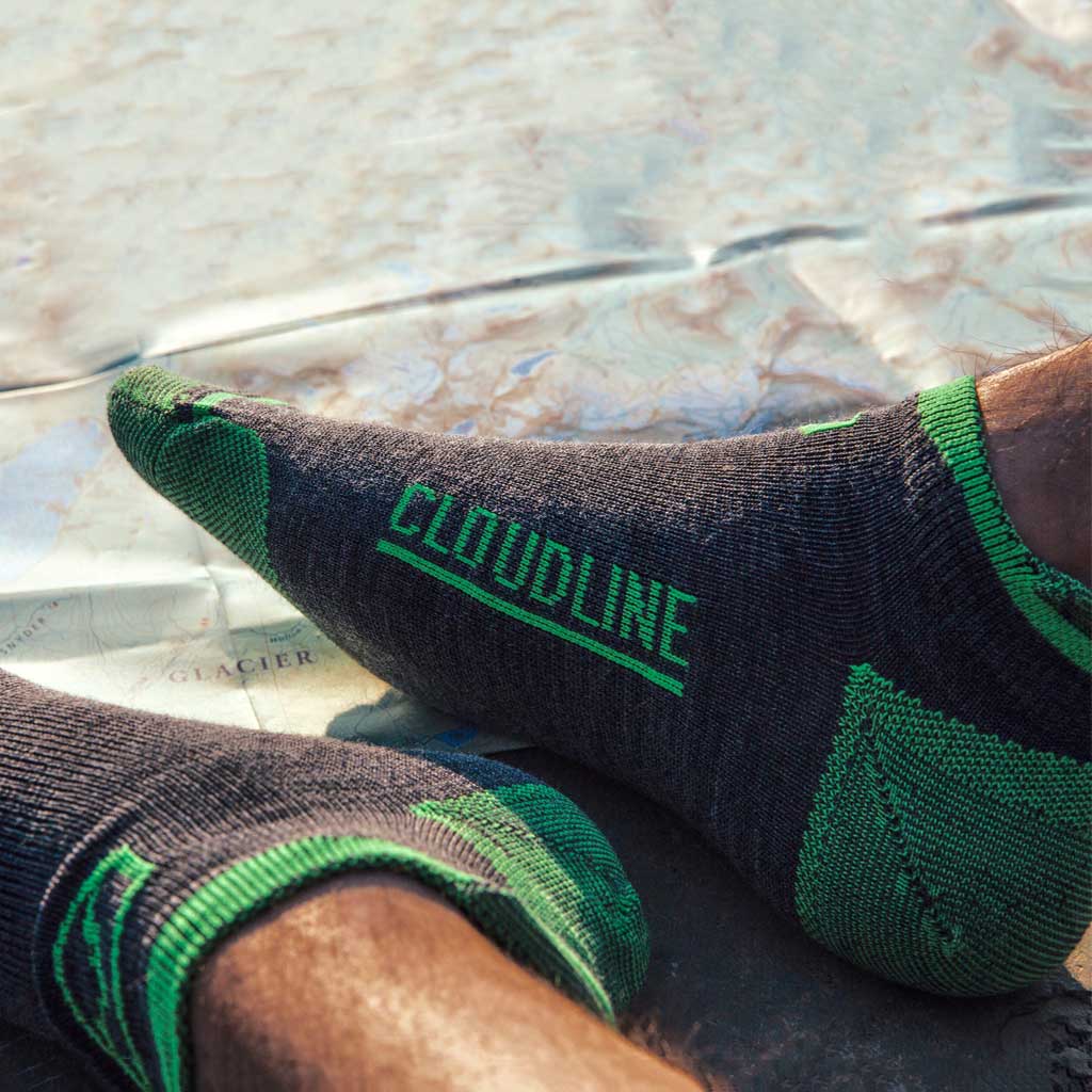 Trail Runner wearing Cloudline merino wool running socks with trail topo map in background.