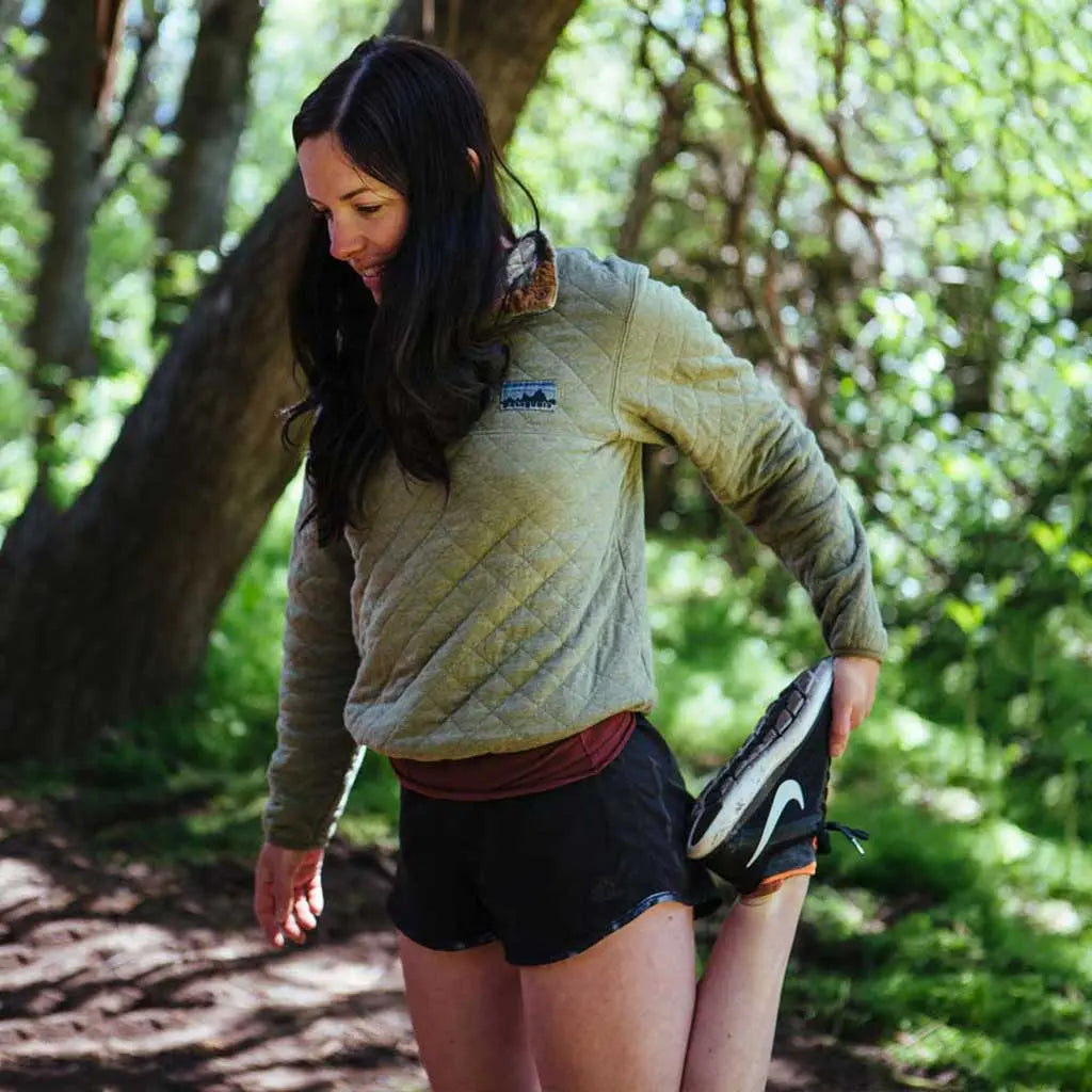 Runner wearing Cloudline merino wool socks stretching after run.
