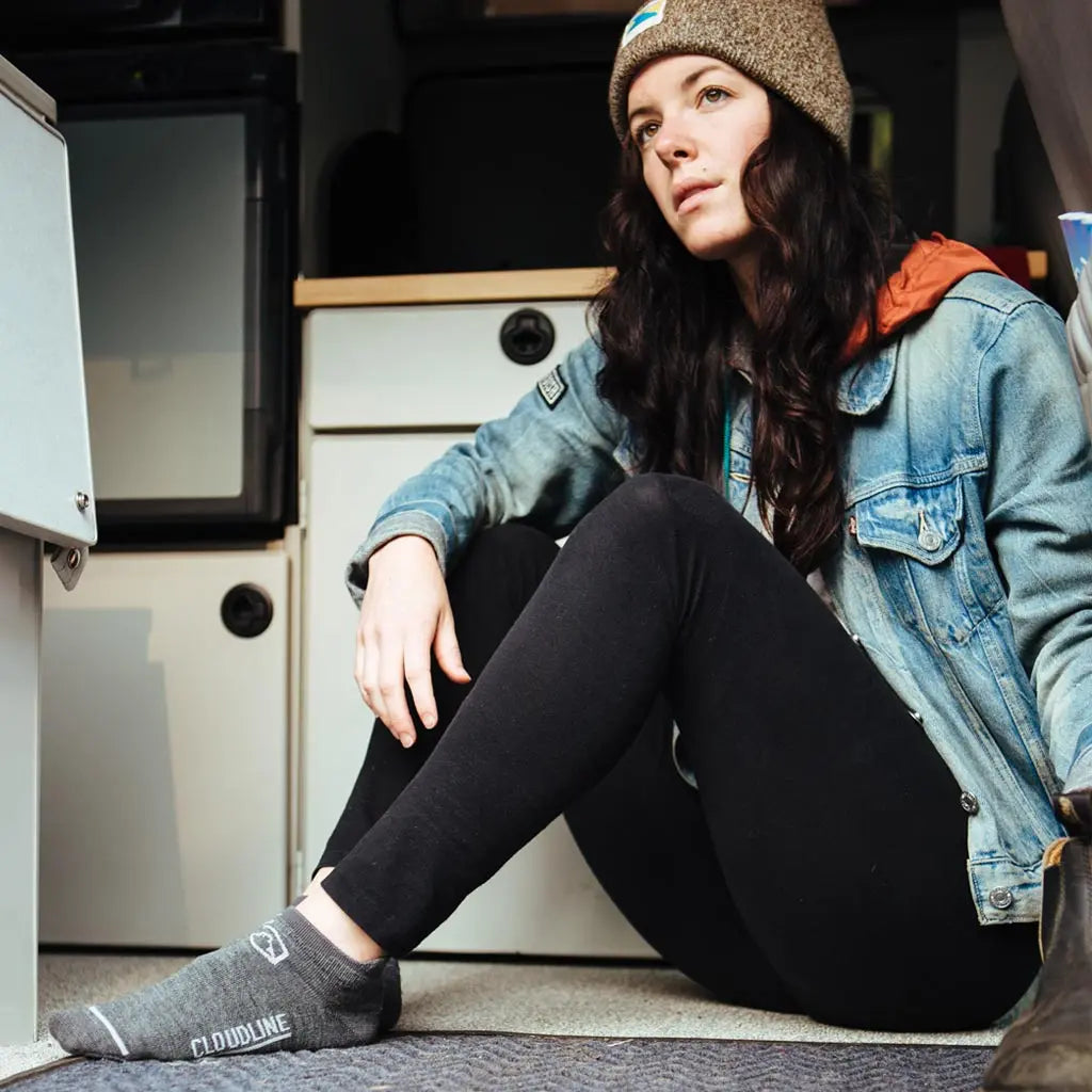 Women wearing Cloudline merino wool no show socks sitting in camper van.