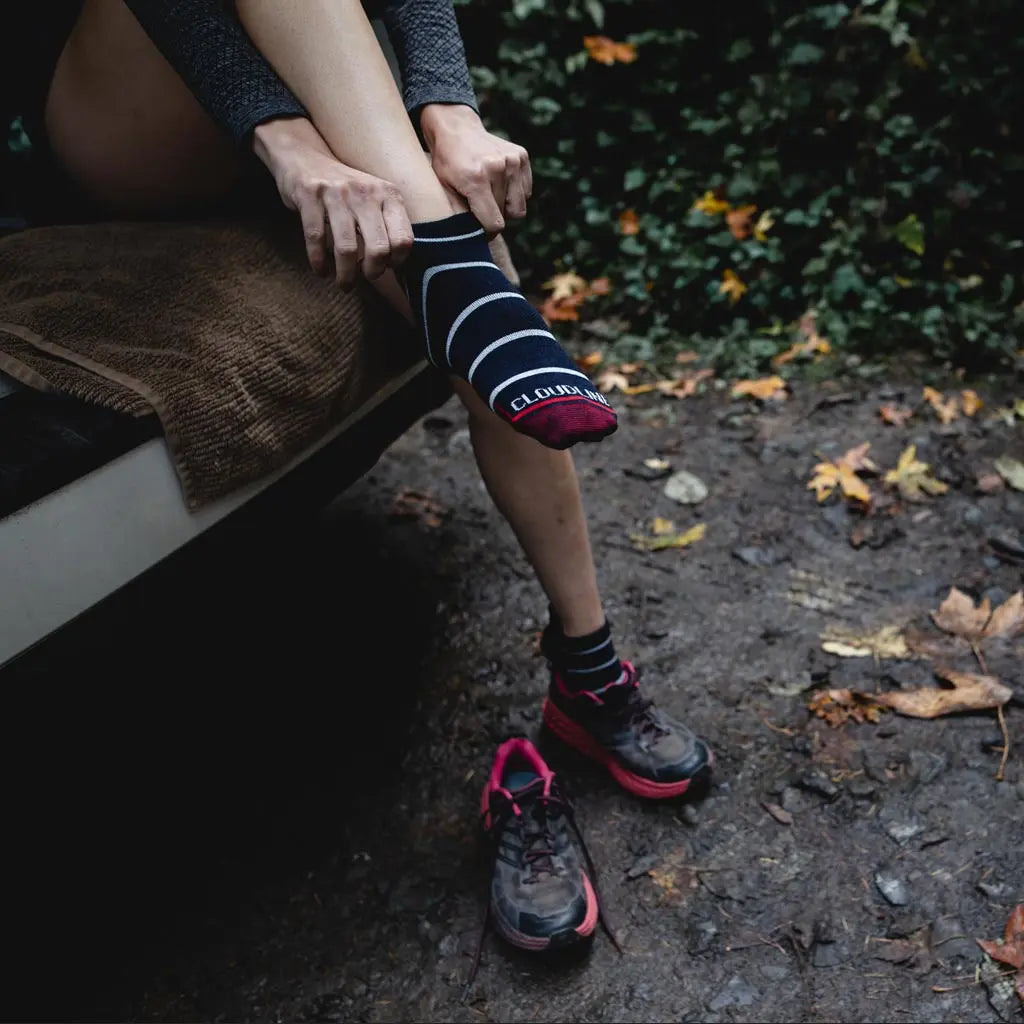 Runner pulling on Cloudline merino wool running socks before run.