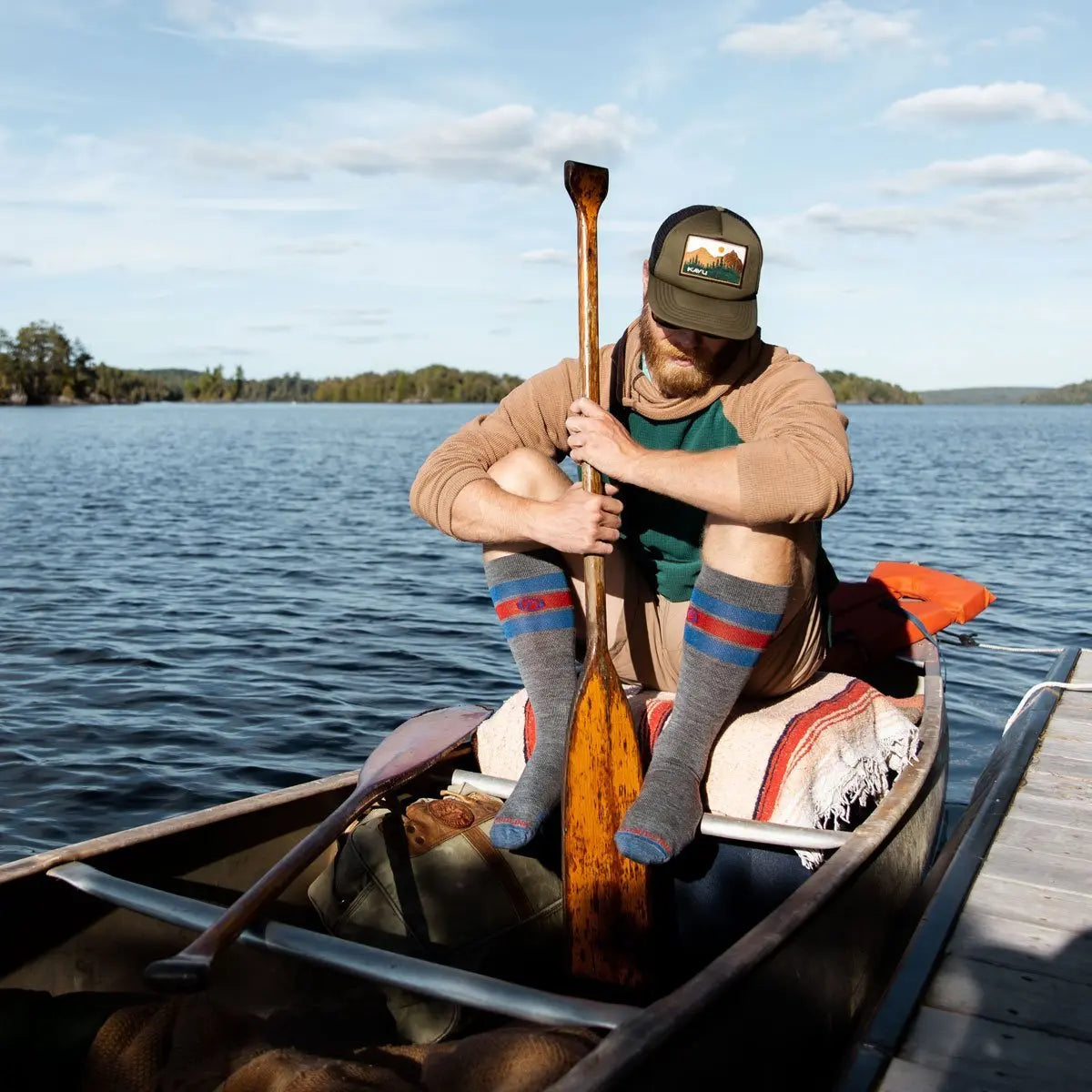 Man wearing Cloudline merino wool compression socks about to push canoe away from dock.