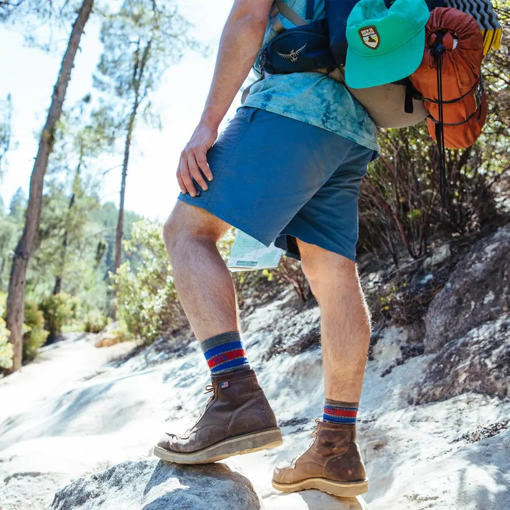 Backpacker wearing Cloudline merino wool hiking socks on rocky trail.