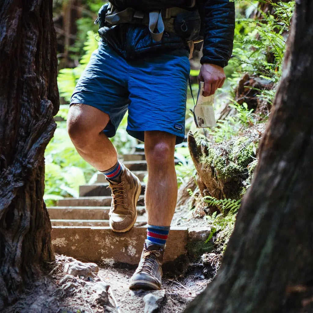 Backpacker hiking towards camera wearing Cloudline merino wool hiking socks.