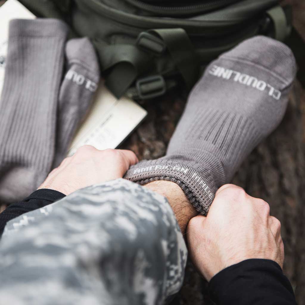 Man pulling on Cloudline tactical socks.