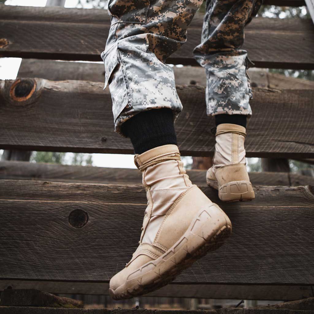 Women wearing Cloudline tactical socks climbing wooden obstacle wall.