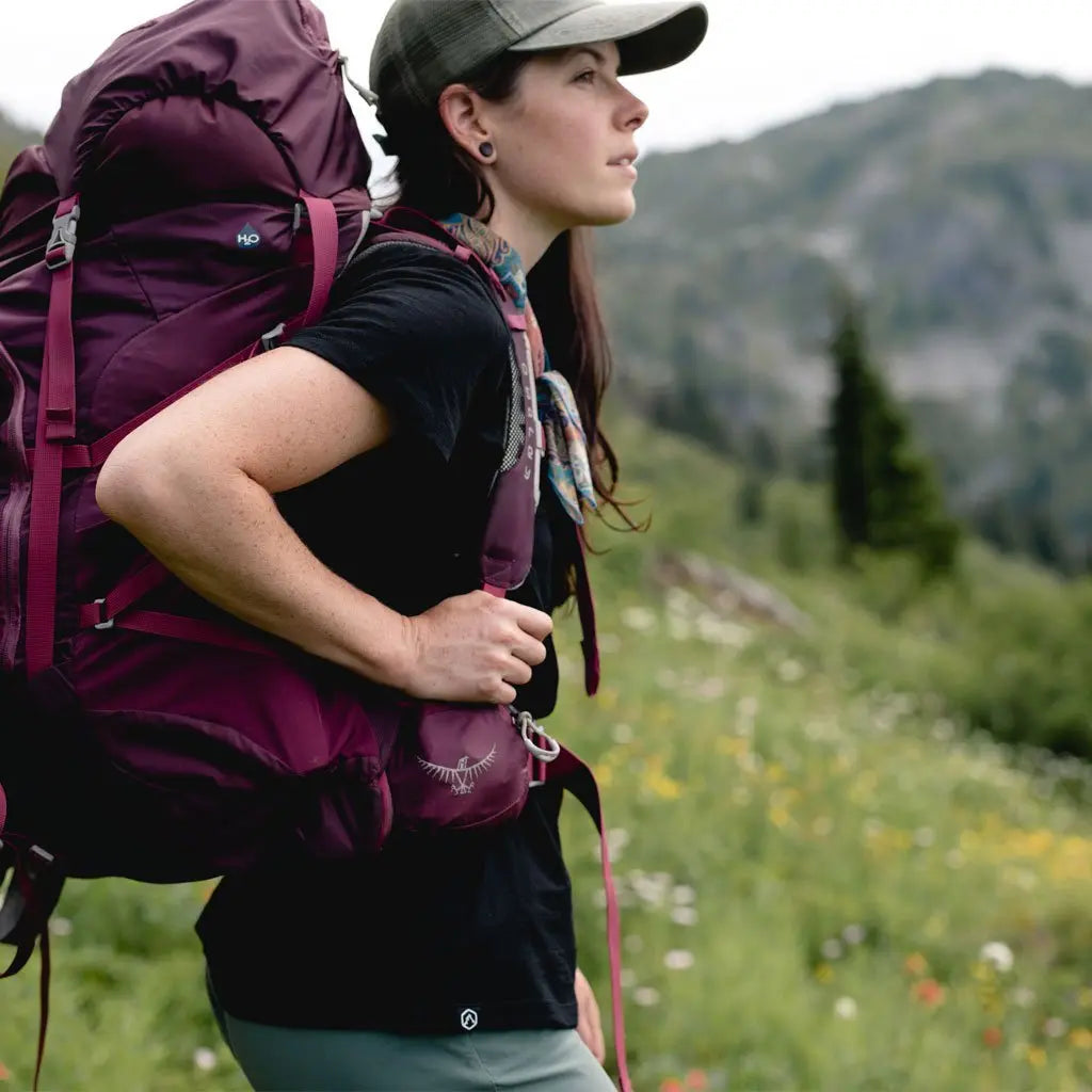 Backpacker wearing Cloudline base layer with mountains in the background.