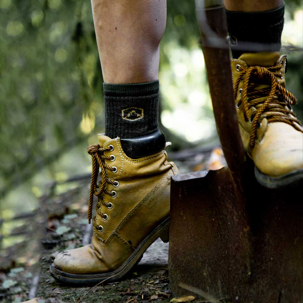 Women wearing Cloudline work socks digging hole with shovel.