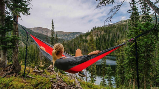 Backpacker relaxing in hammock while camping in the woods.