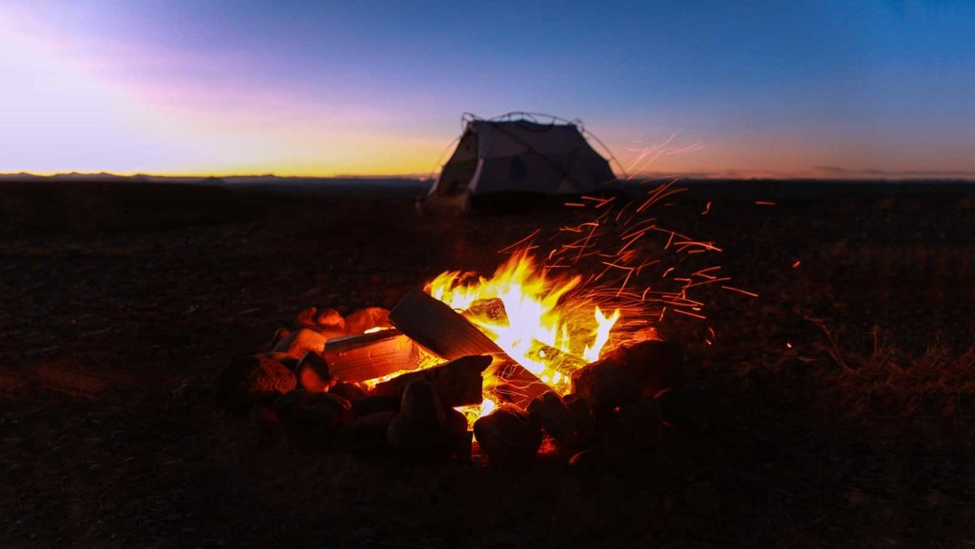 a well built campfire with a tent nearby 