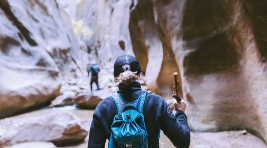 Two people hiking through sandstone canyon.