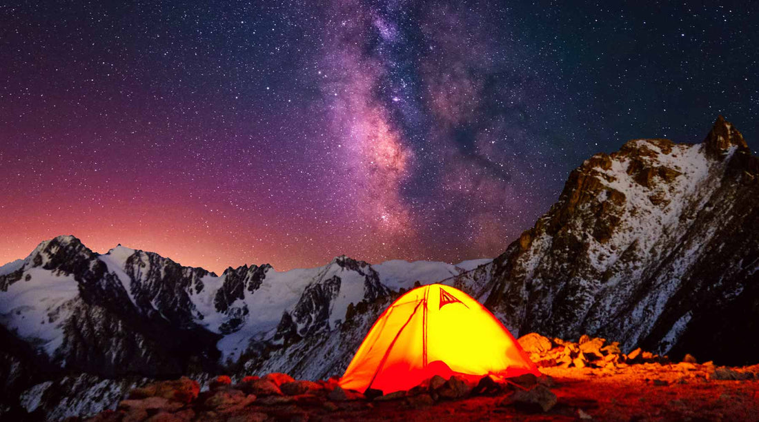 Yellow tent light at night under the stars.
