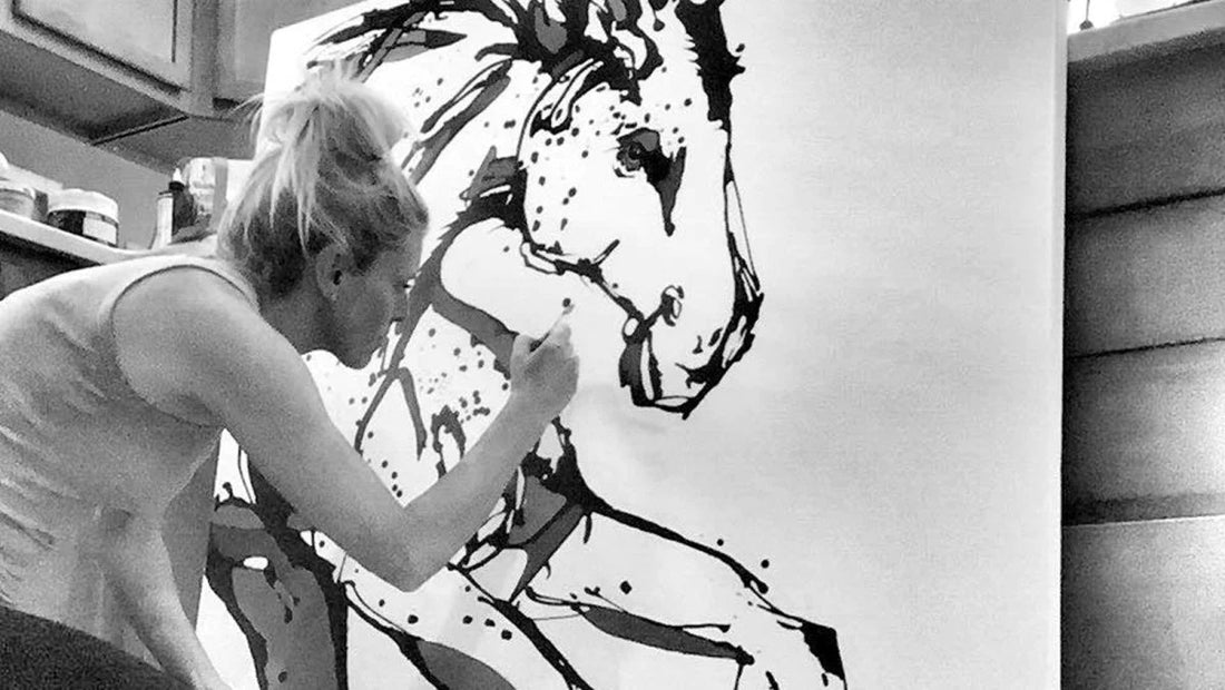Nicole Gaitan painting a horse in her studio.