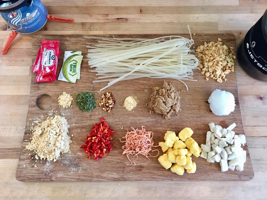 Backpacking pad thai ingredients laid out on cutting board at home.