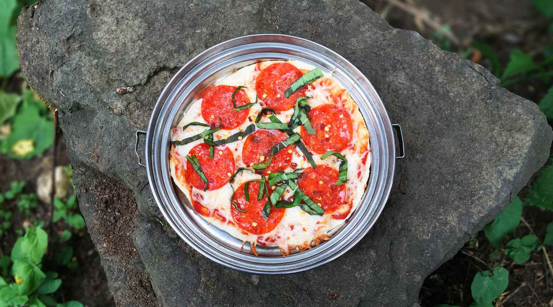 Tortilla Trail Pizza in backpacking pan set on large flat rock as a camp table.