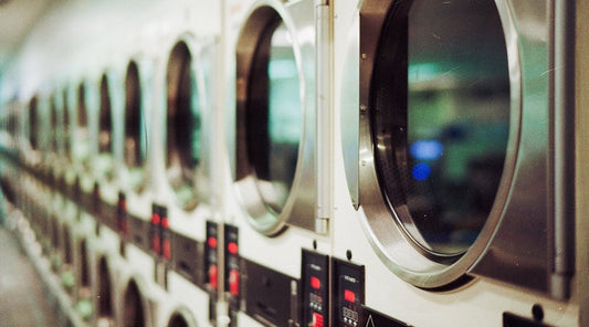 Line of washing machines and dryers at a laundromat. 