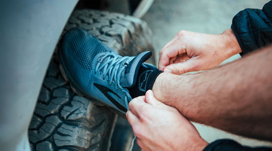 Runner wearing Cloudline merino wool running socks tying shoe laces before a run.