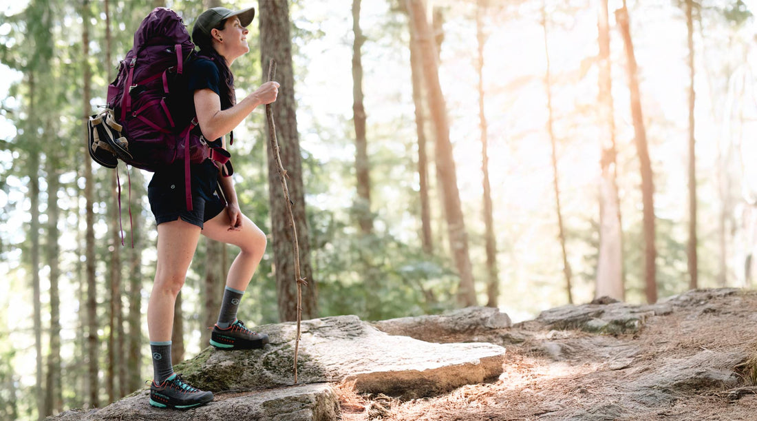 Backpacker wearing Cloudline merino wool socks on hiking trail.