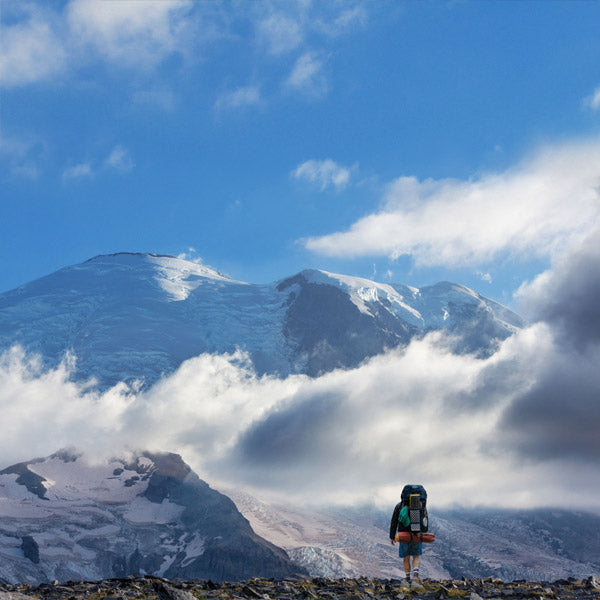 Backpacker wearing Cloudline socks hiking towards Mt Rainier.