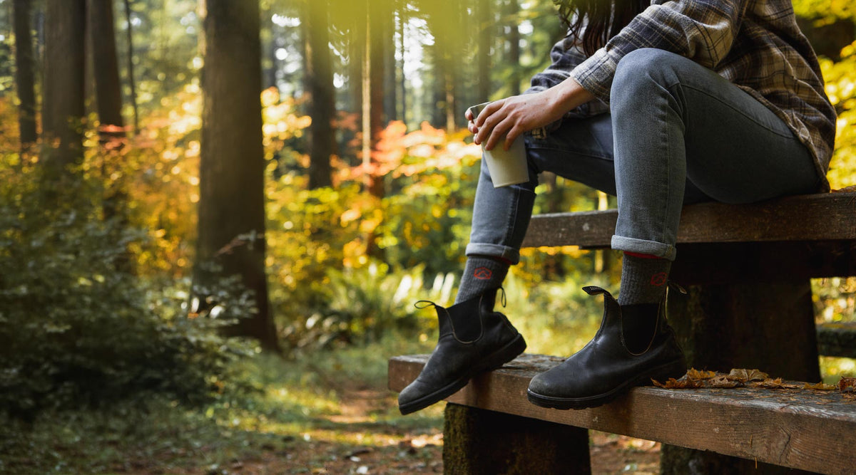 Women wearing Cloudline socks sitting on picnic table.