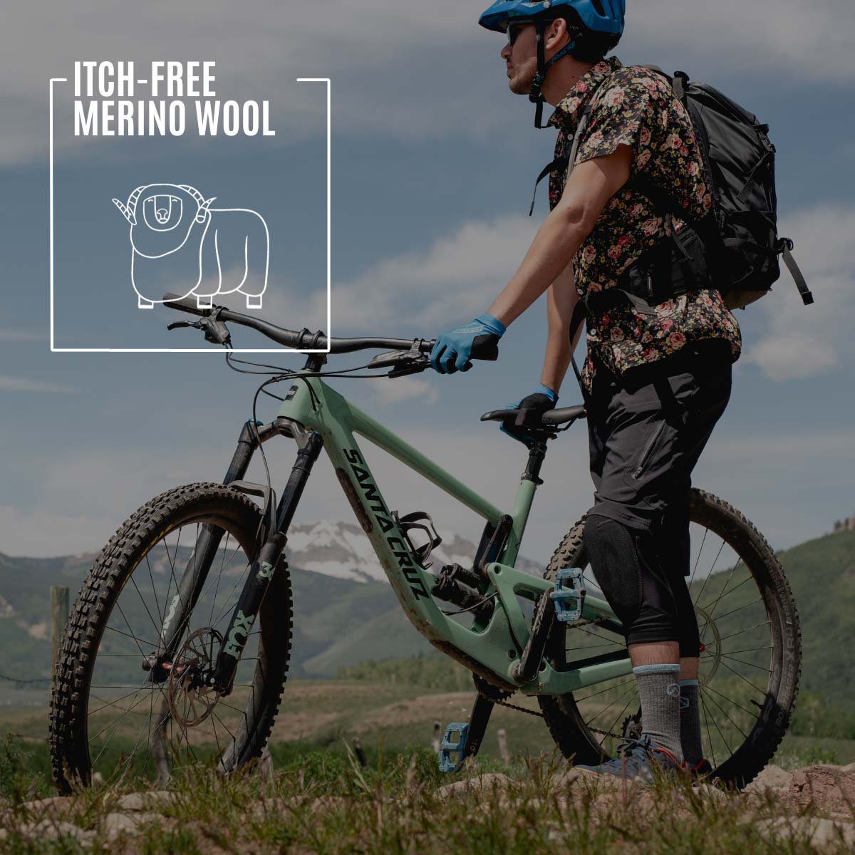 Mountain biker wearing Cloudline socks standing next to bike on mountain trail.