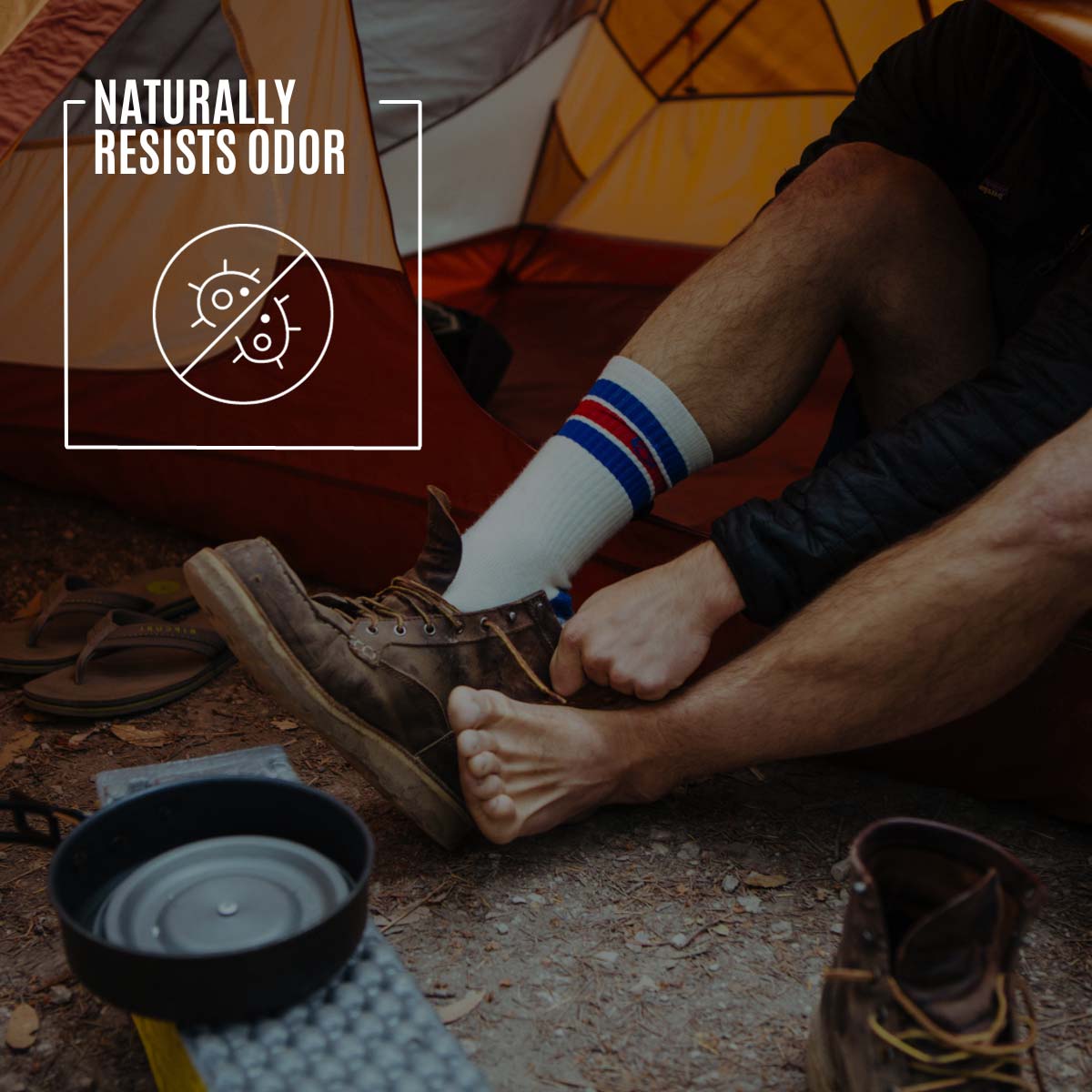 Backpacker sitting in tent doorway putting on Cloudline socks and hiking boots. 