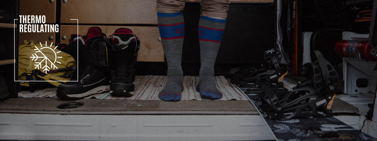 Snowboarder wearing Cloudline socks getting gear ready to hit the slopes. 