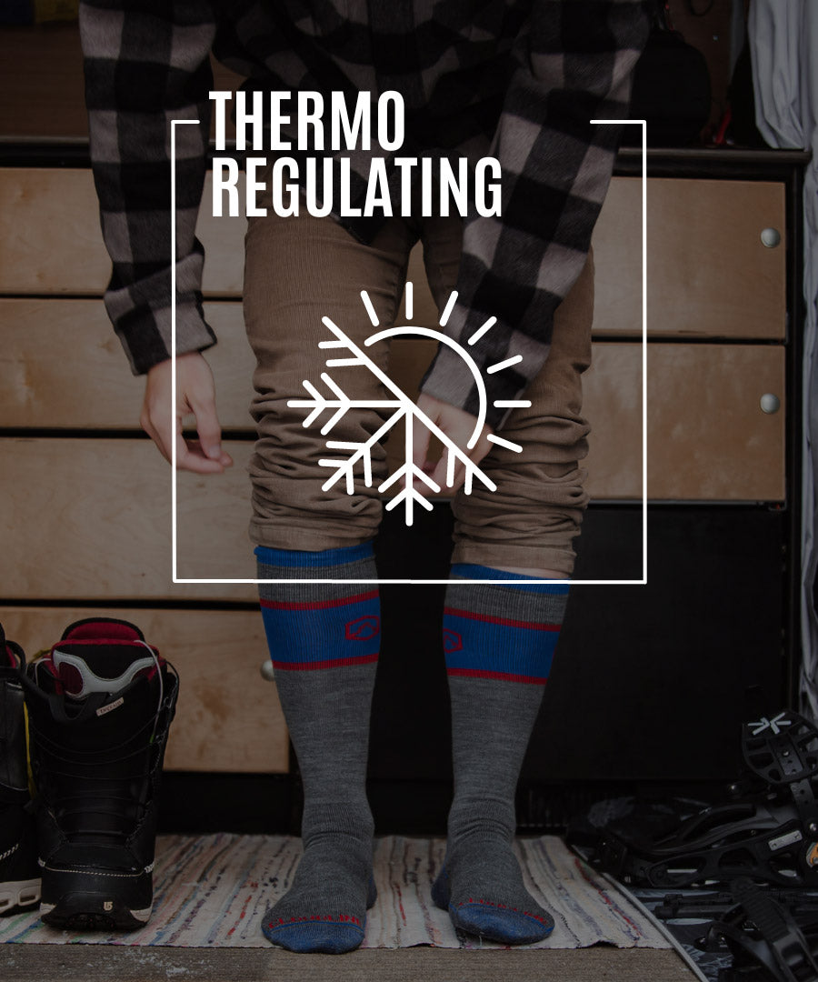 Snowboarder wearing Cloudline socks getting gear ready to hit the slopes. 