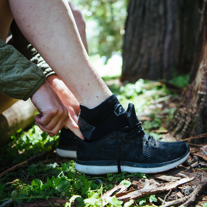 Women putting on Cloudline socks and running shoes. 