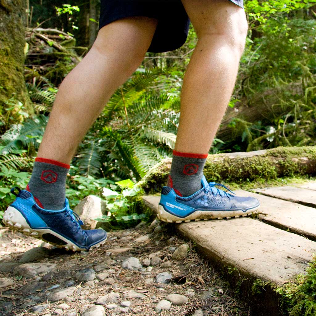 Hiker wearing Cloudline 1/4 Top Running Sock  while crossing wooden trail bridge. 
