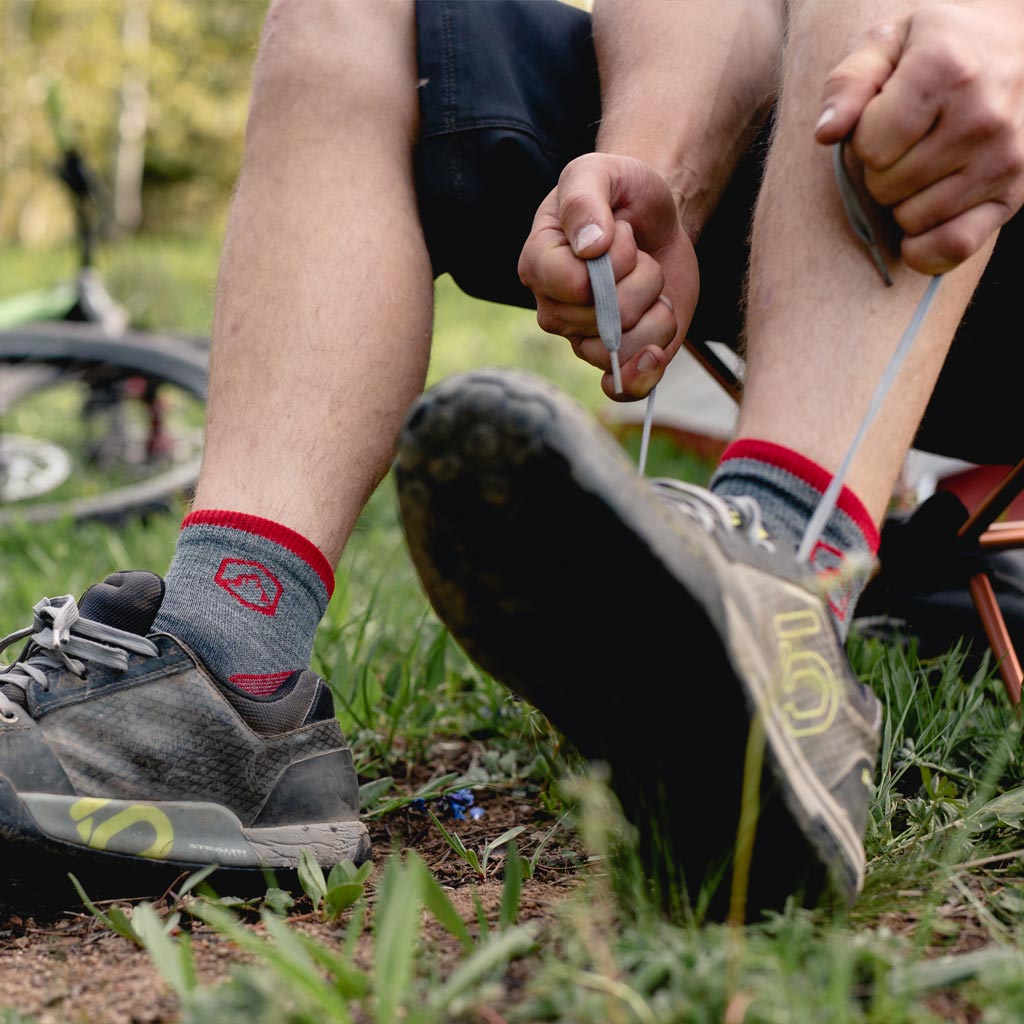 Man wearing Cloudline 1/4 socks putting on trail shoes. 