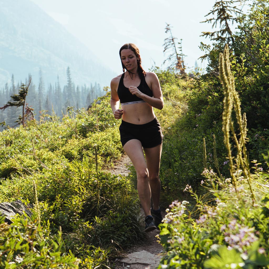 Women wearing Cloudline running socks while running down mountain trail. 